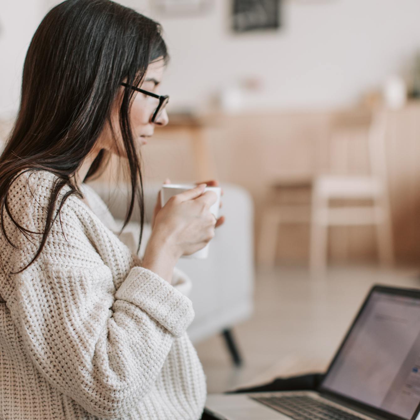Female business owner with long brown hair and glasses viewing a tax and hst report from Marulanda Business Solutions.